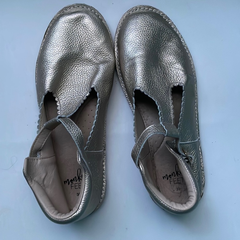Metallic women’s T strap monkey feet